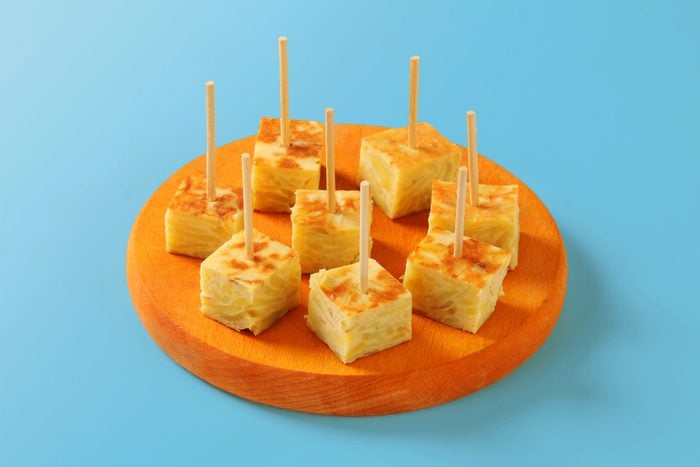 tray of free samples with toothpicks on a wood tray, blue background