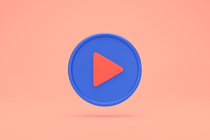 video play button floating on peach background