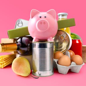array of Groceries With Piggy Bank on pink background