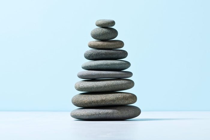 meditation stones Stacked In Order Of Size on blue background