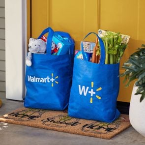 Walmart Plus Grocery Delivery bags on a front porch