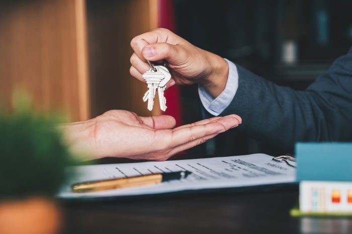 Agent hands over house keys in an office over an agreement