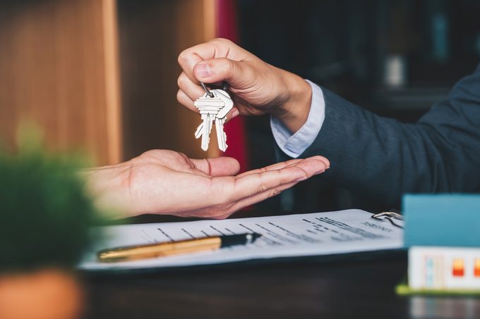 Agent hands over house keys in an office over an agreement