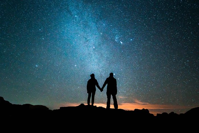 Couple silouette standing in front of the milky way
