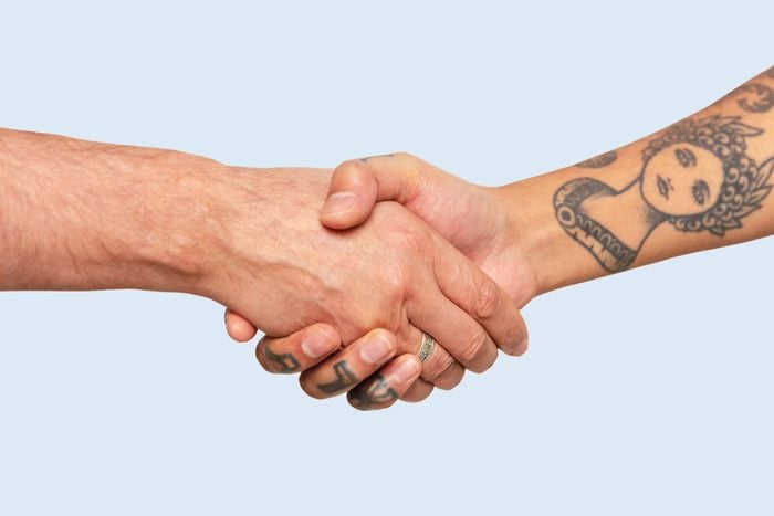 Обрезанные руки друзей-мужчин, рукопожатие на белом фоне