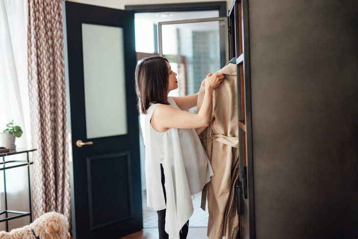 Young Woman Choosing Outfits From Wardrobe, Getting Ready To Go Out