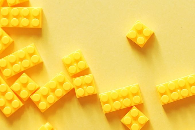 Yellow toy brick blocks on yellow background