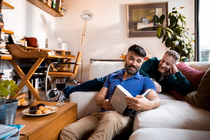 Male couple reading a book together