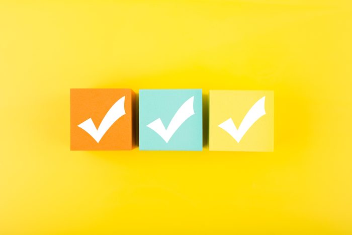 Three checkmarks on colorful blocks against bright yellow background