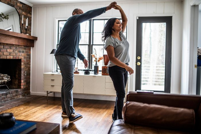 Married couple dancing in residential living room