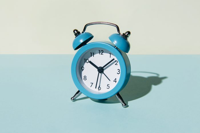 Alarm clock on a blue and beige background