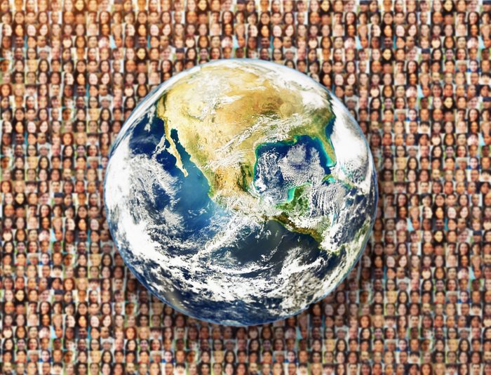 Planet Earth against a background of hundreds of human faces