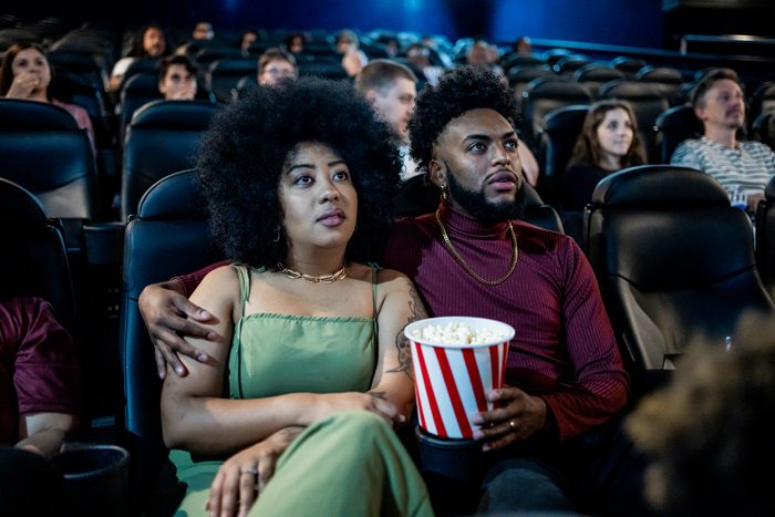 Black couple watching movie at cinema