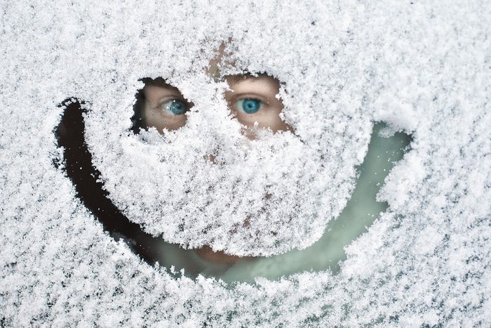 Man Peeking Through Snow Covered Window