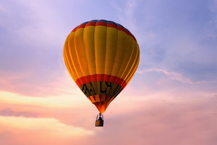 Colorful hot air balloon on sunset sky.