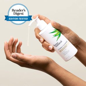 hands holding a bottle of vitamin c cleanser