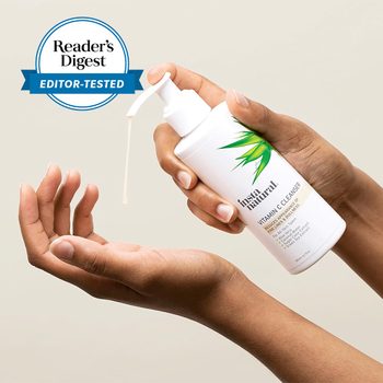 hands holding a bottle of vitamin c cleanser