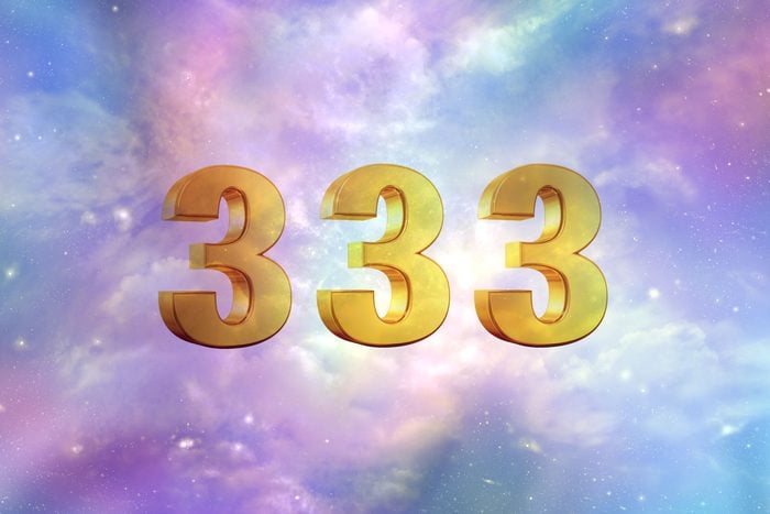 gold metallic three dimensional "333" in a pastel cloudy sky