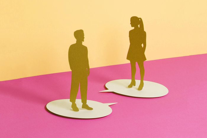 paper cut outs of a man and woman standing on speech bubbles talking to eachother