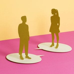 paper cut outs of a man and woman standing on speech bubbles talking to eachother