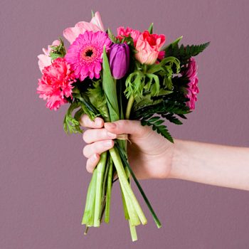 anonymous arm and hand Holding Bunch Of Flowers for an apology