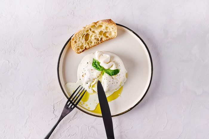 Burrata Cheese on a plate With Ciabatta Bread And Fork and knife