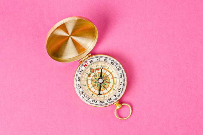 Gold ornate Compass open On Pink Background