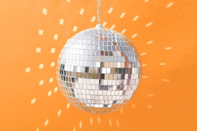 disco ball with light reflecting on orange background