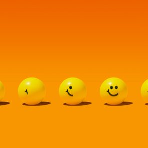 five yellow balls on an orange background; from left to right, the smiley face is more revealed to symbolize practicing gratitude to increase happiness