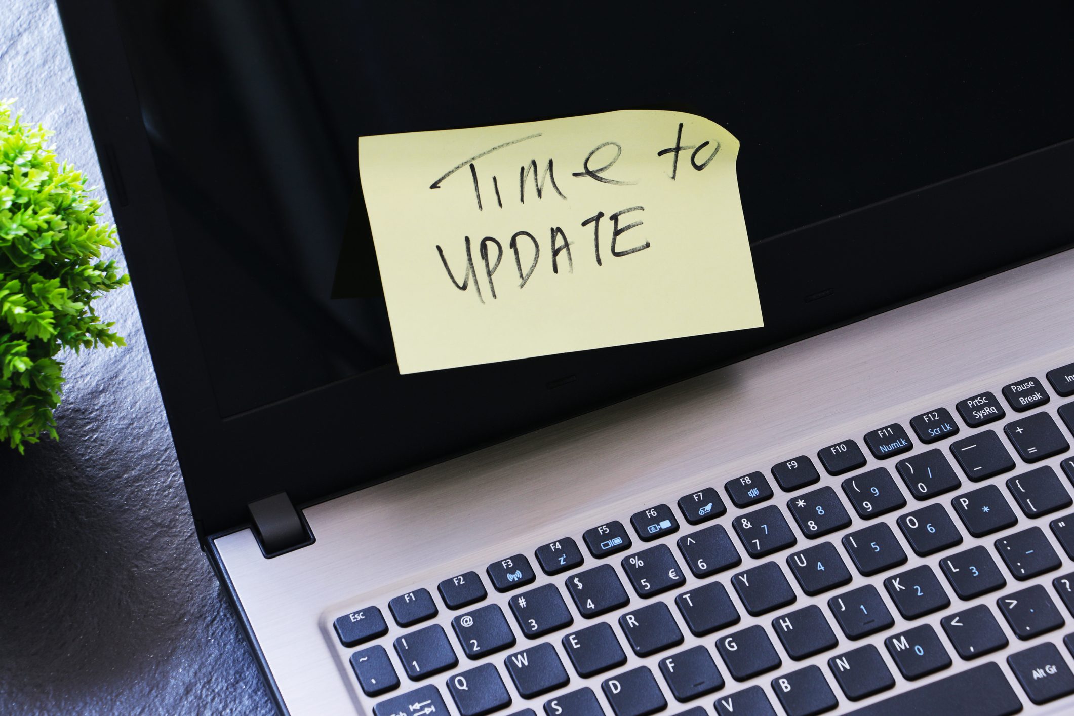 Laptop and yellow paper on screen with text written 'Time to update'