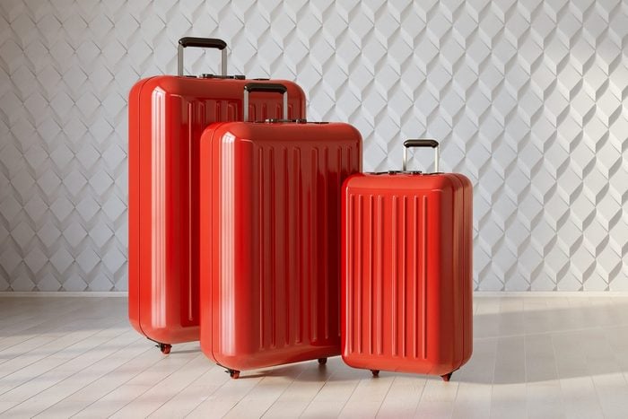 Three Red Suitcases in White Interior