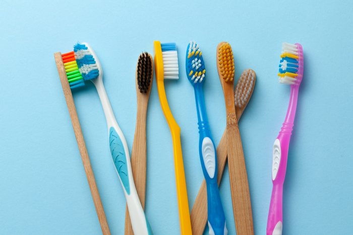 Colored toothbrushes on blue background.