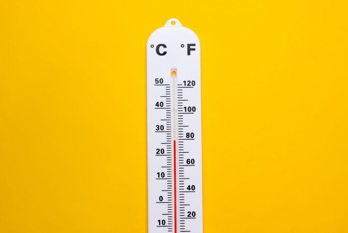 Weather thermometer on yellow background. Climate control. Top view