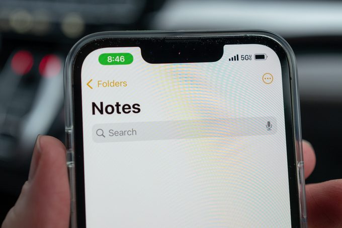 Person holds iPhone with screen showing the Notes app