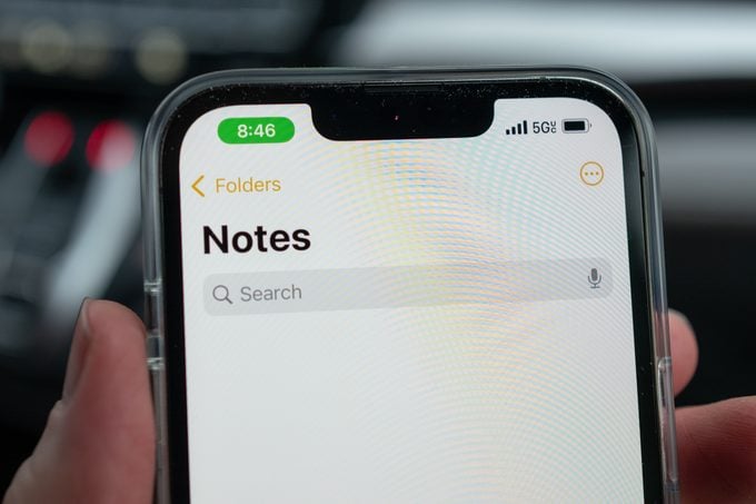 Person holds iPhone with screen showing the Notes app