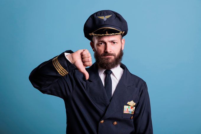 Serious airplane aviator with thumbs down gesture