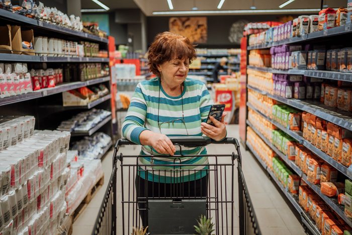 Senior woman checking shopping list on smartphone