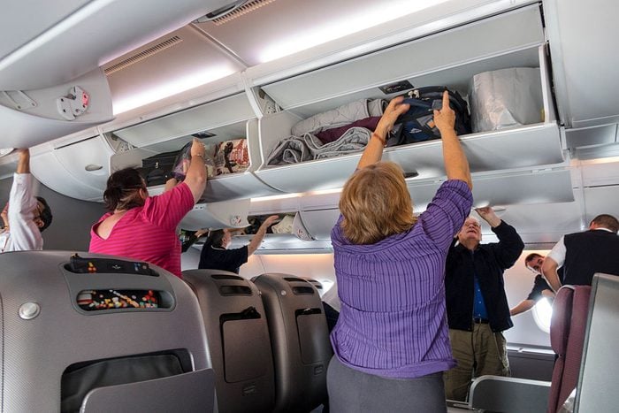 Australia, Melbourne Qantas airlines cabin business class passengers disembarking overhead luggage bins