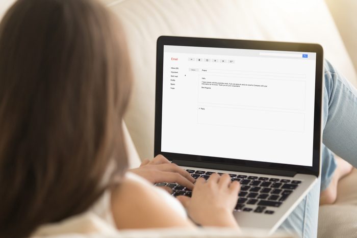Woman typing electronic mail using laptop, sending e-mail, maili