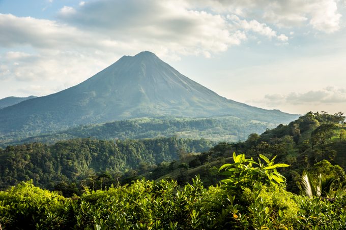 Landscape shot of the Arenal Volcano in Costa Rica with lush vegetation in the foreground