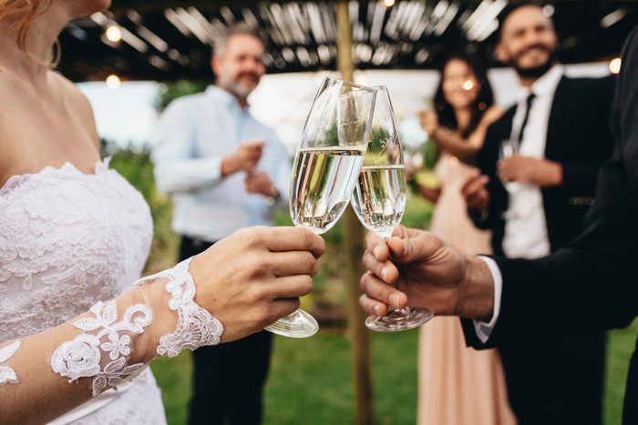 Newlyweds clinking glasses at wedding reception