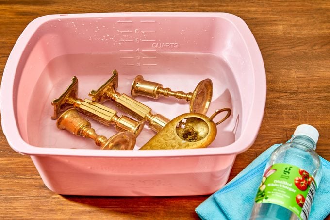 brass items soaking in a plastic bin