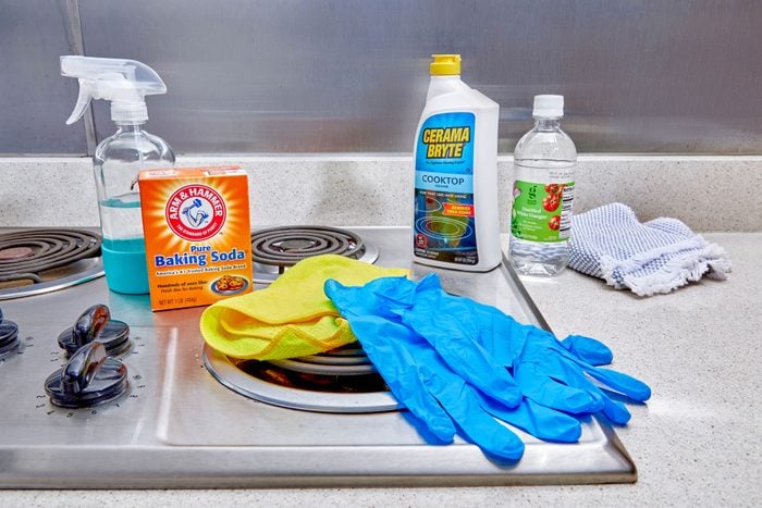 How To Clean An Electric Stove Top, cleaning supplies arranged on an electric stove top