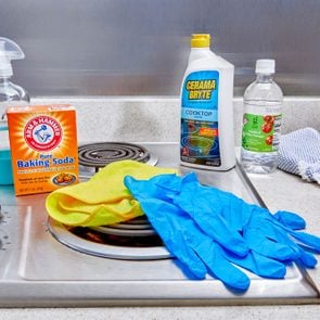 How To Clean An Electric Stove Top, cleaning supplies arranged on an electric stove top