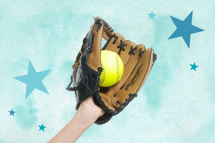 Hand wearing a softball glove holding a softball