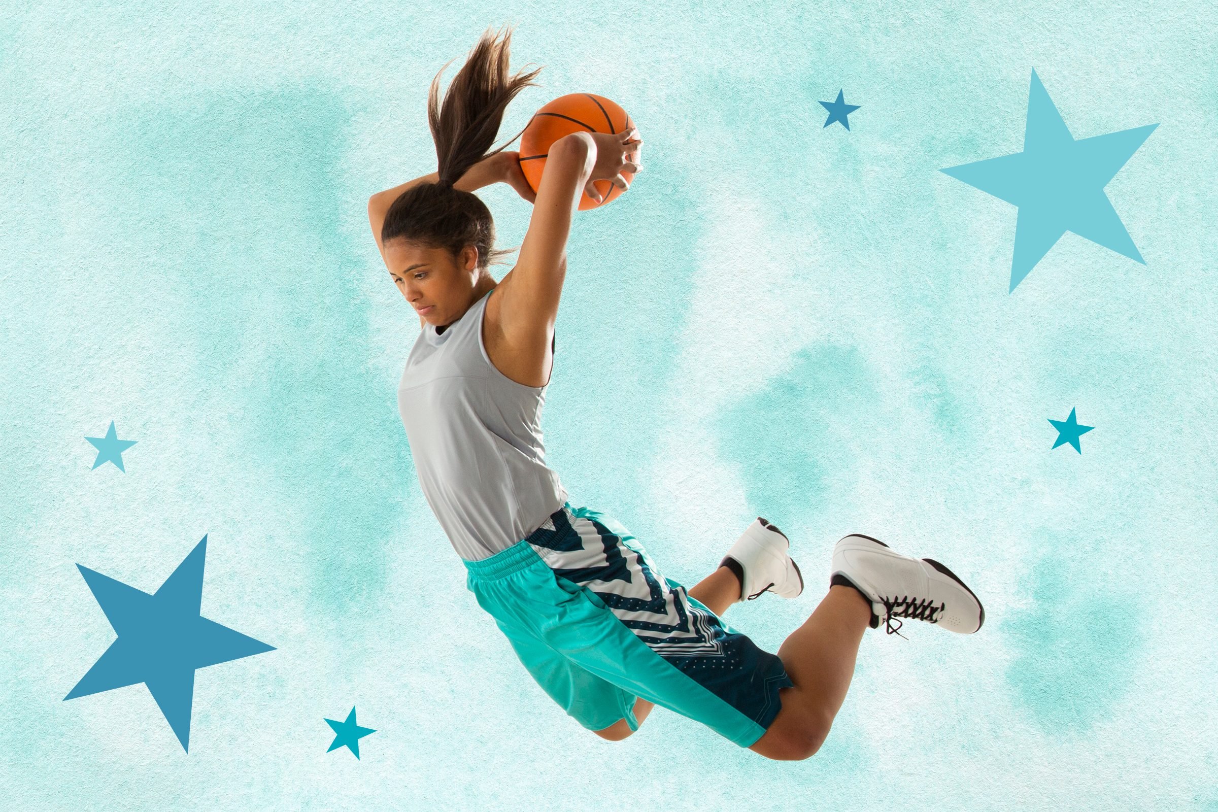 Girl jumping in the air about to dunk a basketball