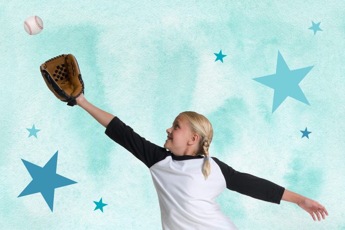 Girl reaching to catch a baseball with a baseball glove