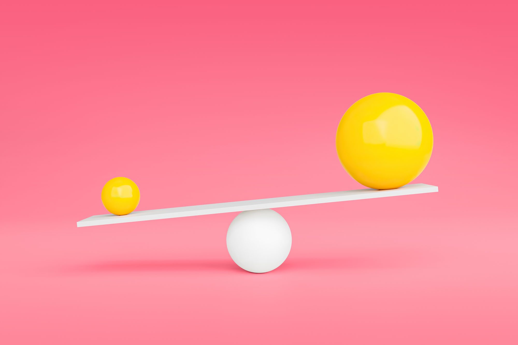 two yellow spheres on either end of a balance on pink background; the smaller ball is the heavier ball
