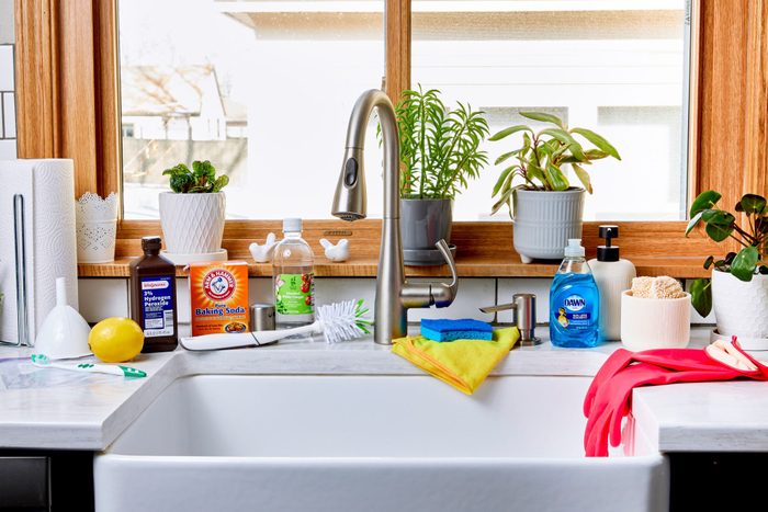 Kitchen sink in a modern kitchen with supplies for cleaning all around it