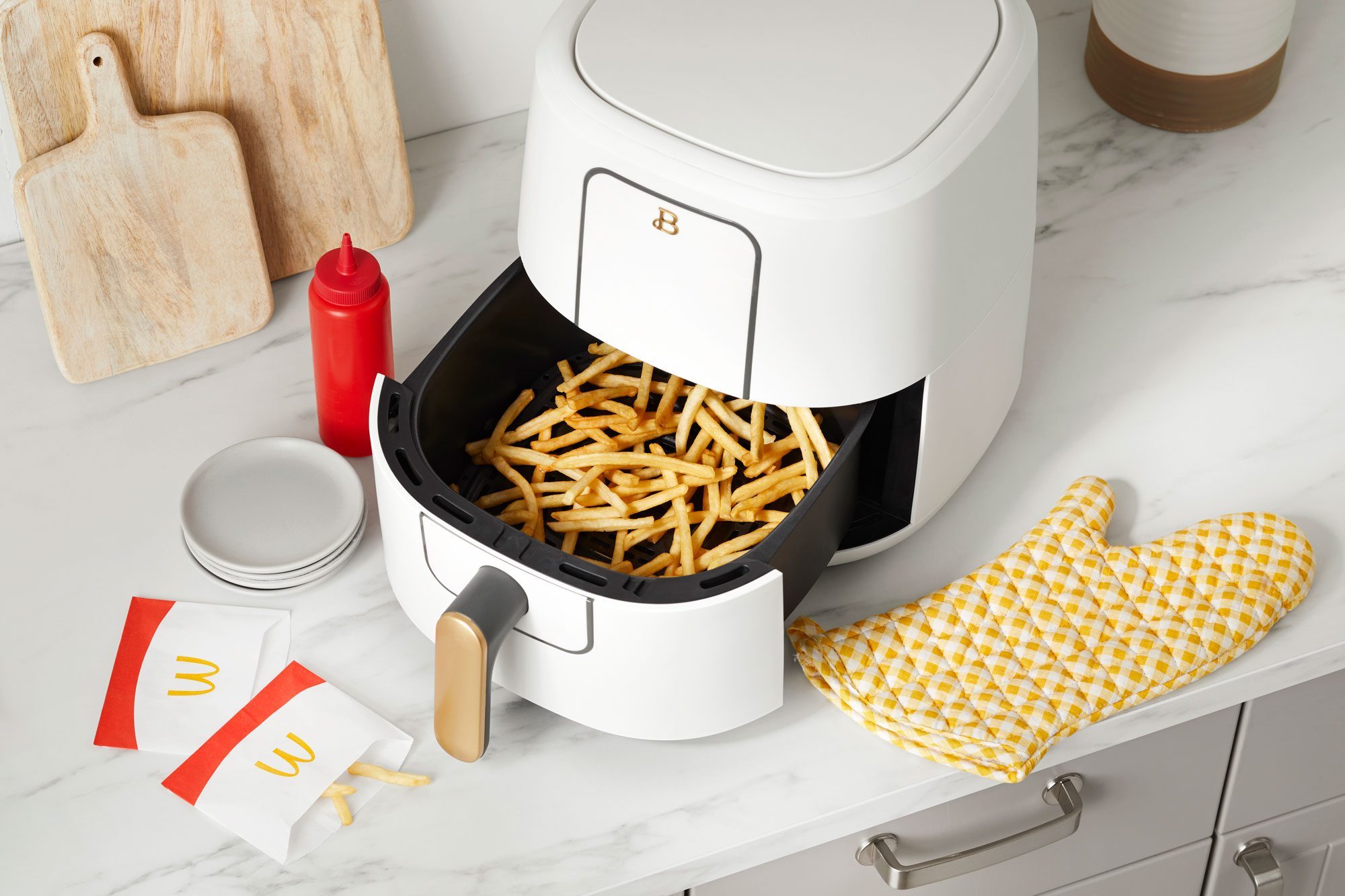 mcdonalds fries in the basket of an open air fryer on a kitchen counter